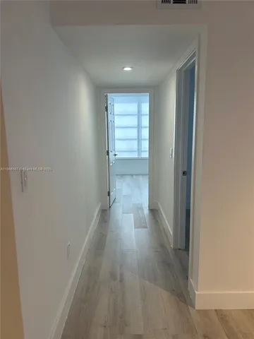 a view of a hallway with wooden floor