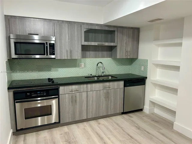 a kitchen with stainless steel appliances granite countertop a stove and a microwave