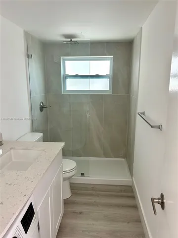 a bathroom with a granite countertop sink toilet and shower