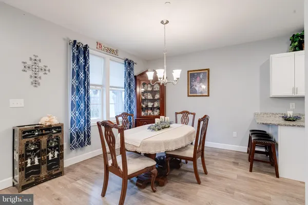 a kitchen with stainless steel appliances granite countertop a refrigerator a sink dishwasher a stove a microwave oven with white cabinets and wooden floor