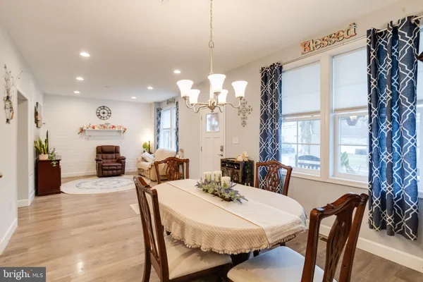 a kitchen with stainless steel appliances granite countertop a refrigerator a sink dishwasher and white cabinets with wooden floor
