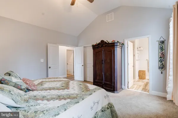 a bedroom with a bed and a dresser next to a window