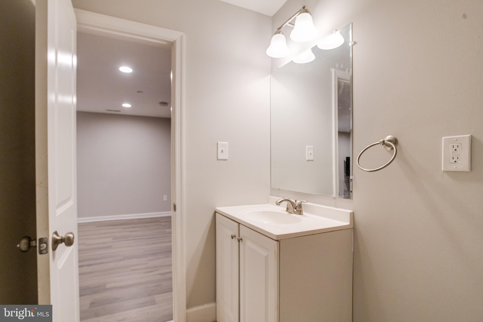 708 Hyde Park Road Essex, MD 21221 - Photo 61 of 65 a bathroom with a sink a light fixture and a mirror