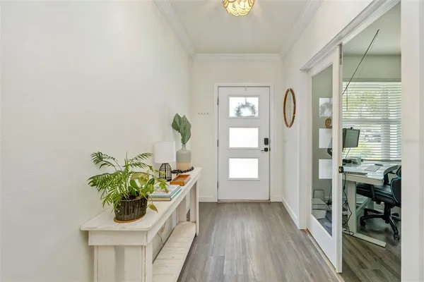 a kitchen with stainless steel appliances kitchen island granite countertop a table chairs in it and white cabinets