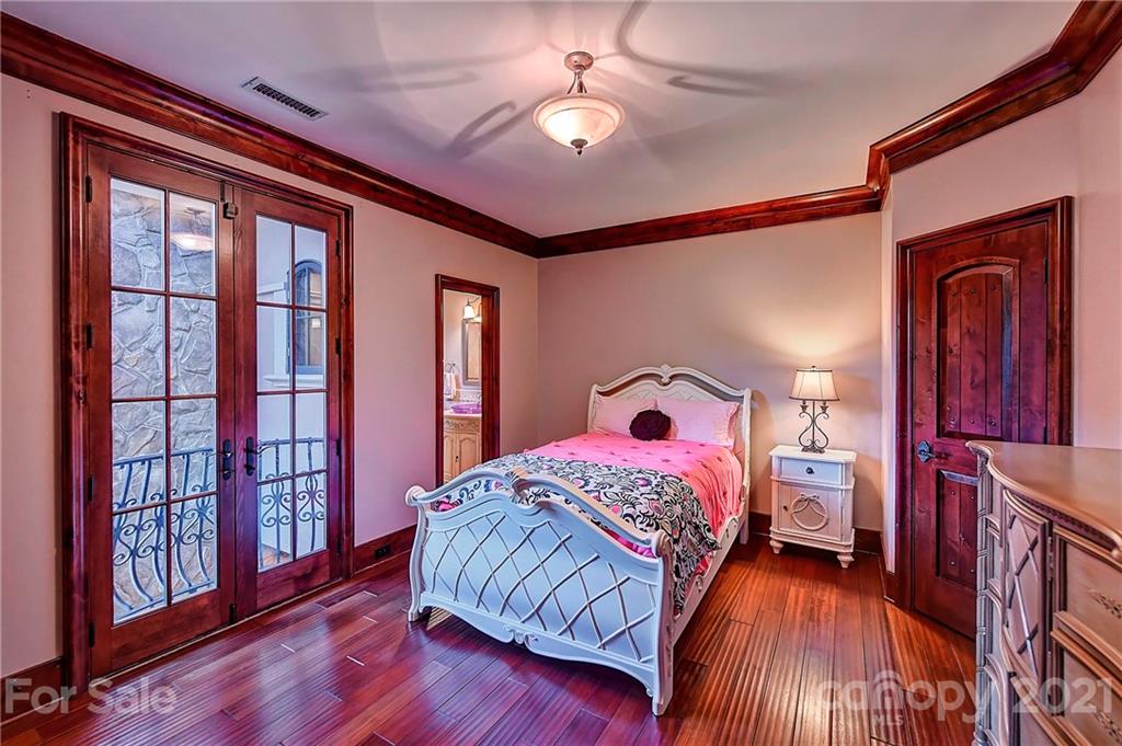 21123 Torrence Chapel Road Cornelius, NC 28031 - Photo 29 of 35 a bedroom with a large bed and a chandelier