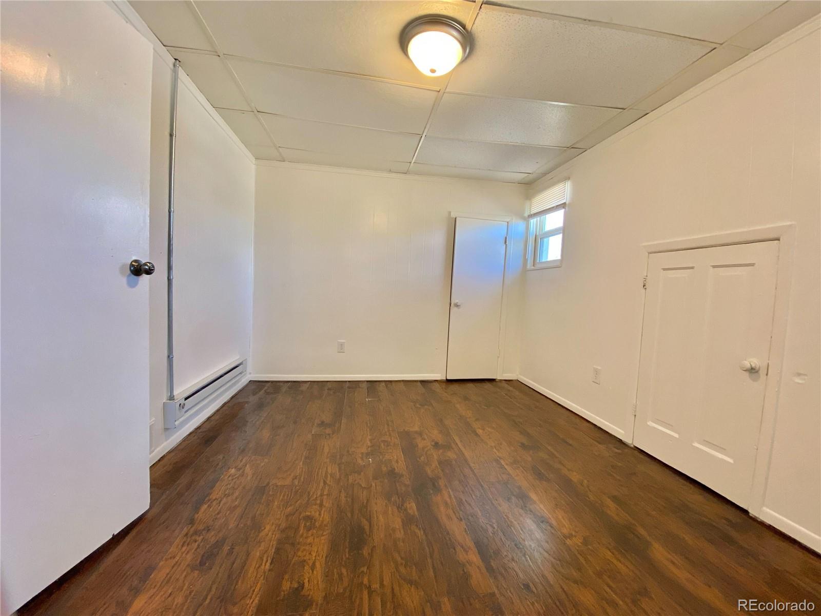2422 West Vermijo Avenue, Unit 3 Colorado Springs, CO 80904 - Photo 6 of 7 an empty room with wooden floor and windows