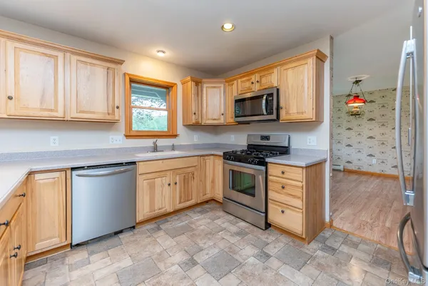 a kitchen with stainless steel appliances granite countertop a stove a sink and a microwave