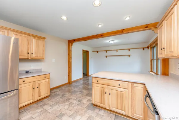 a kitchen with white cabinets and wooden floors
