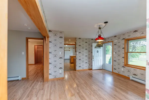 a view of empty room with wooden floor and windows