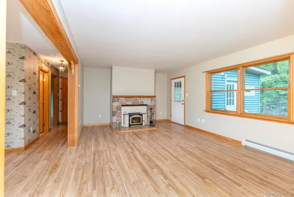 a view of empty room with wooden floor and fireplace