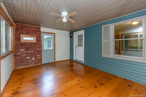 a view of a livingroom with wooden floor and a ceiling fan