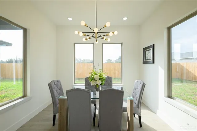 a view of a dining room with furniture a chandelier and wooden floor