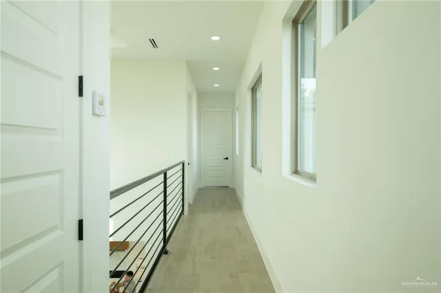 a view of a hallway with wooden floor and staircase