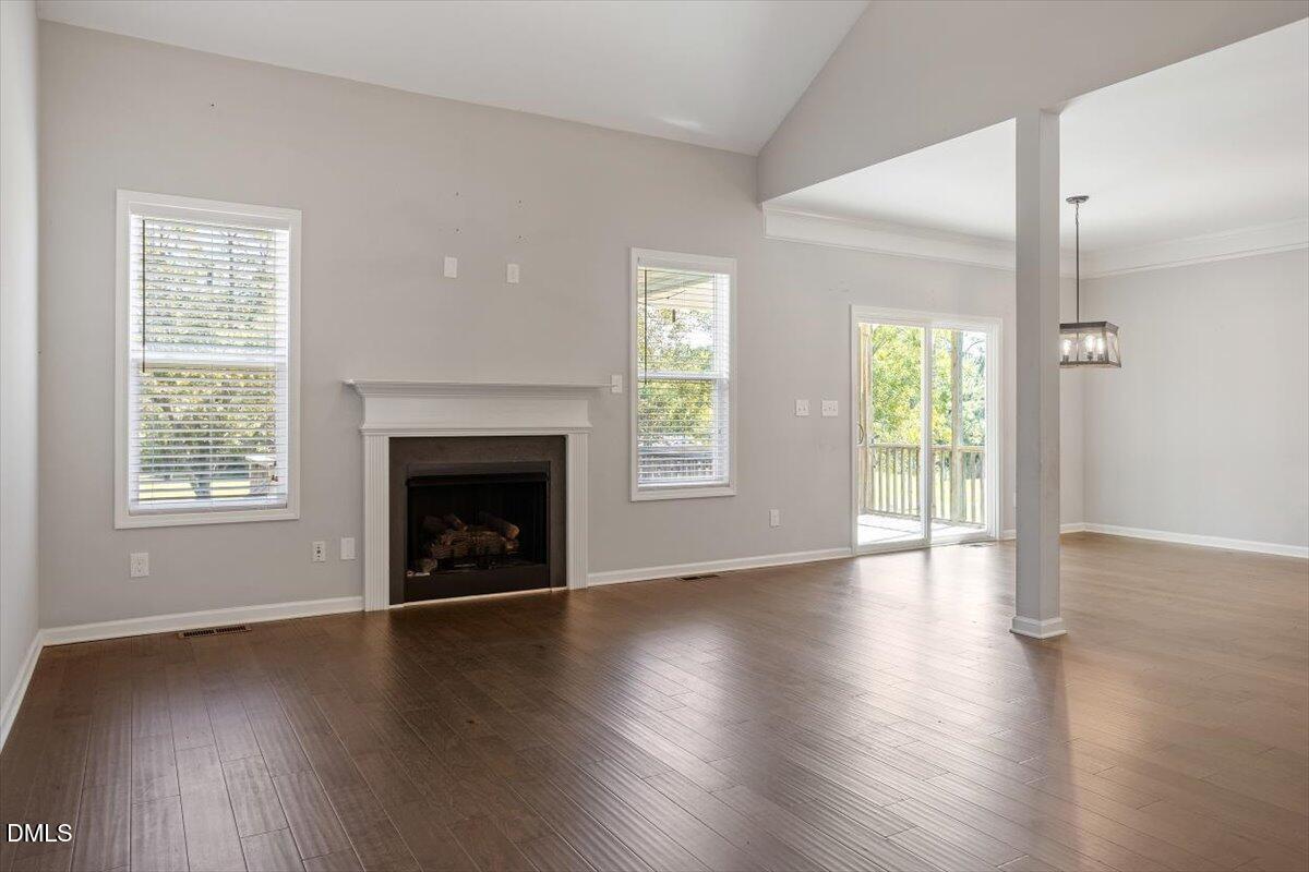 3361 Old Fairground Road Angier, NC 27501 - Photo 16 of 40 an empty room with wooden floor fireplace and windows