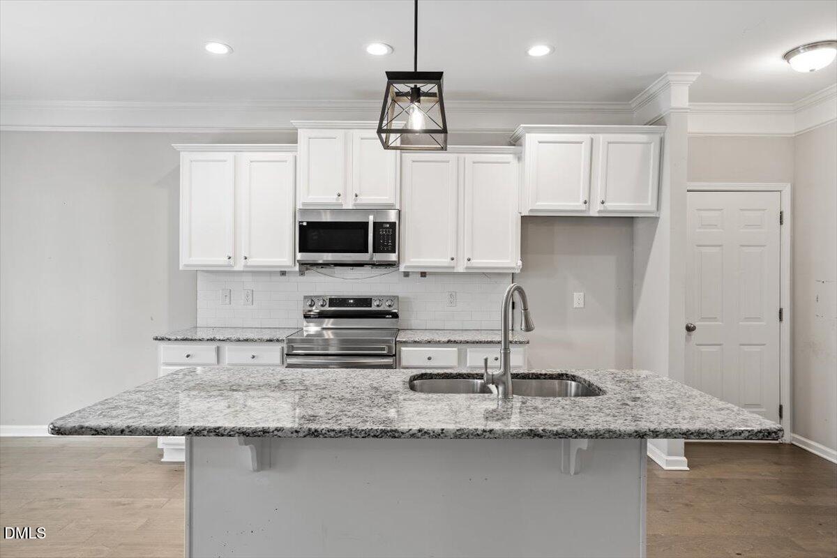 3361 Old Fairground Road Angier, NC 27501 - Photo 24 of 40 a kitchen with granite countertop a sink a counter top space cabinets and stainless steel appliances