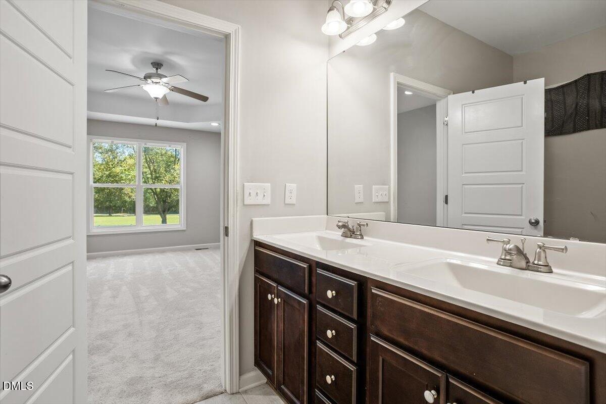 3361 Old Fairground Road Angier, NC 27501 - Photo 31 of 40 a bathroom with a granite countertop sink a large mirror and a window