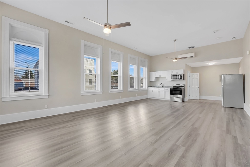 76-96 Maple Street Northampton, MA 01062 - Photo 11 of 22 a view of an empty room with wooden floor kitchen view and a window