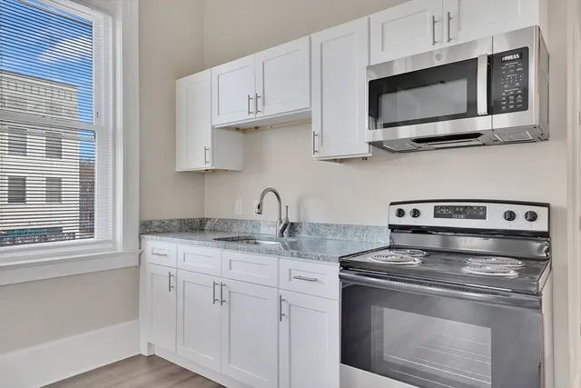 a stove top oven sitting inside of a kitchen