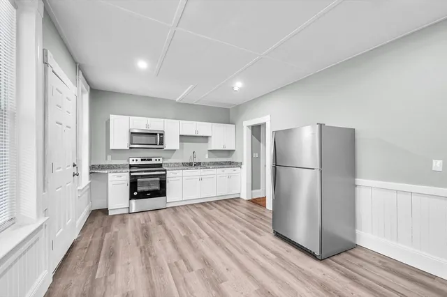 a kitchen with a refrigerator a stove top oven and white kitchen island