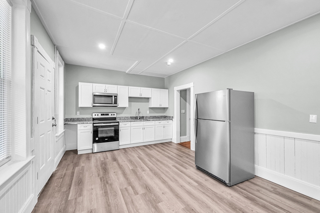 76-96 Maple Street Northampton, MA 01062 - Photo 5 of 22 a kitchen with a refrigerator a stove top oven and white kitchen island