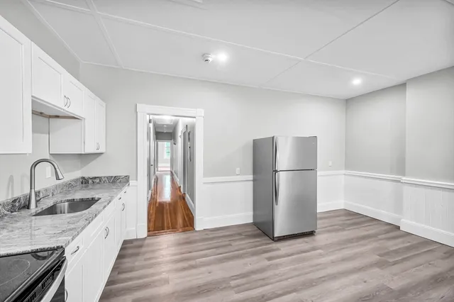 a kitchen with a sink a refrigerator and cabinets