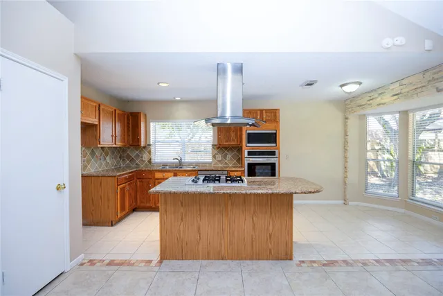a kitchen with stainless steel appliances granite countertop a stove a sink and a refrigerator
