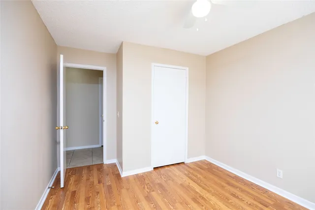 an empty room with wooden floor and closet