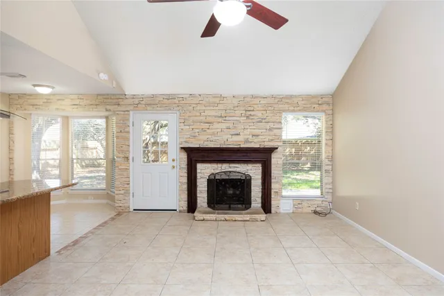 an empty room with windows and fireplace
