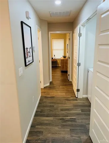 a view of a hallway with wooden floor and entryway