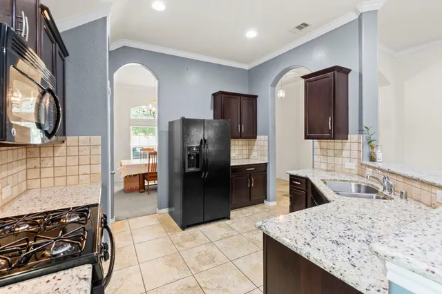 a kitchen with stainless steel appliances granite countertop a sink stove and refrigerator