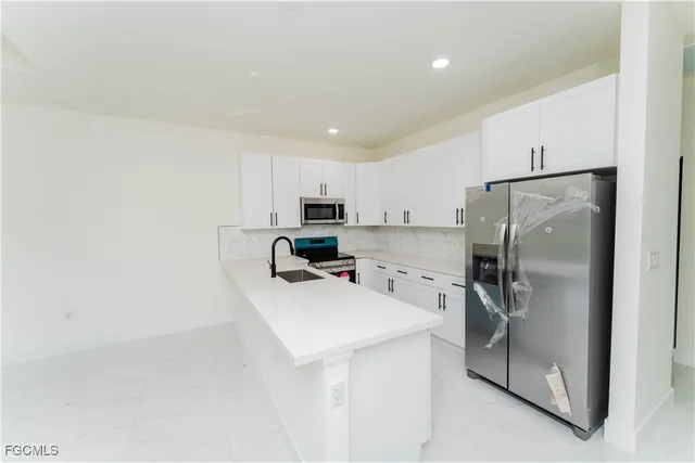 a kitchen with a refrigerator a sink and cabinets