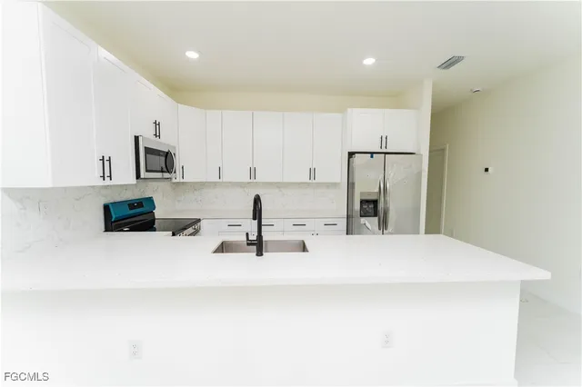 a kitchen with stainless steel appliances a refrigerator sink and microwave