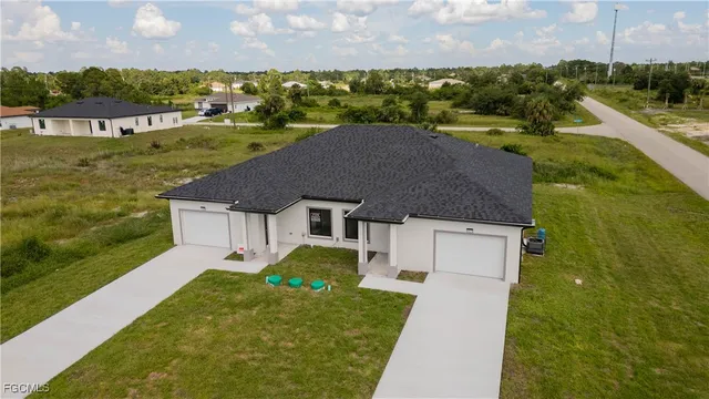a aerial view of a house with a yard and lake view