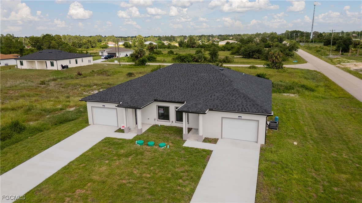 1171 Countess Avenue Lehigh Acres, FL 33974 - Photo 2 of 15 a aerial view of a house with a yard and lake view