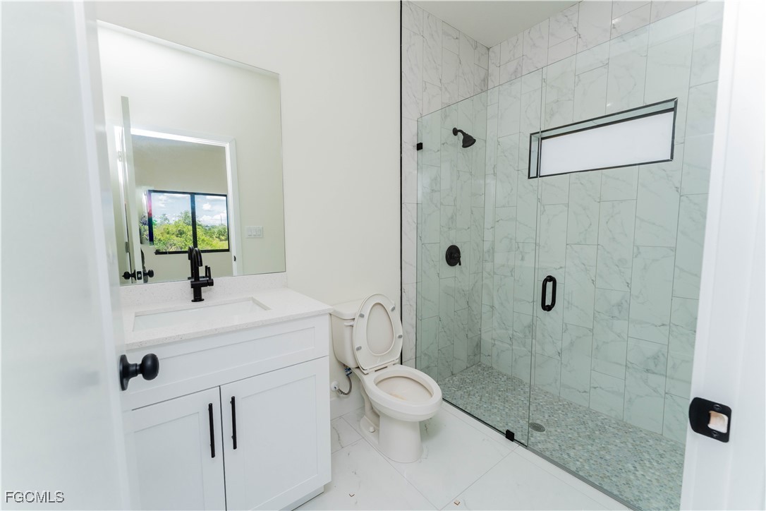 1171 Countess Avenue Lehigh Acres, FL 33974 - Photo 3 of 15 a bathroom with a sink a toilet and shower