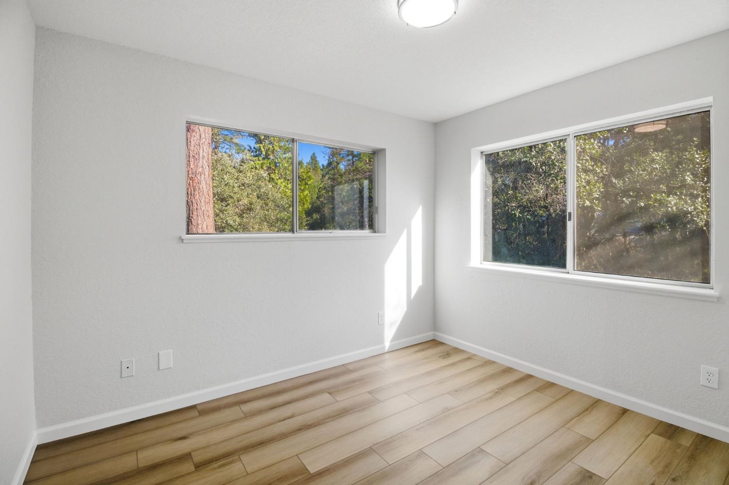 19088 Hillhaven Road Tuolumne, CA 95379 - Photo 13 of 27 a view of an empty room with wooden floor and a window