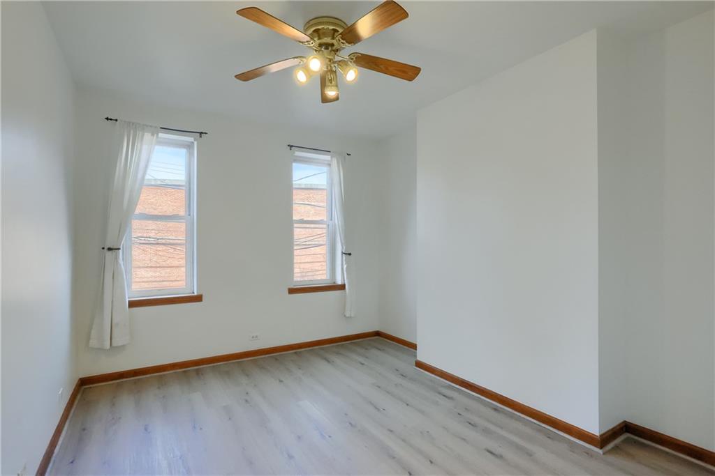 2810 Sarah Street, Unit 2 Pittsburgh, PA 15203 - Photo 16 of 27 an empty room with wooden floor chandelier fan and windows