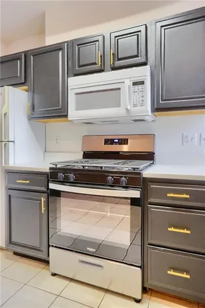 a kitchen with stainless steel appliances granite countertop a refrigerator sink a stove and white cabinets