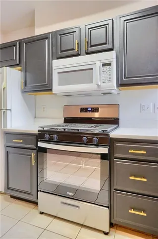 a kitchen with stainless steel appliances granite countertop a refrigerator sink a stove and white cabinets