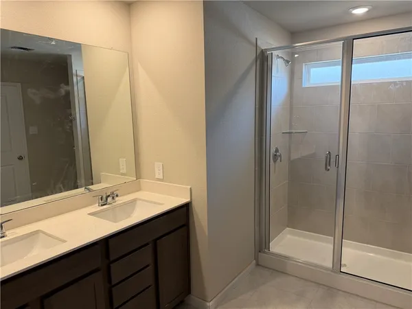 a bathroom with a shower sink vanity and mirror