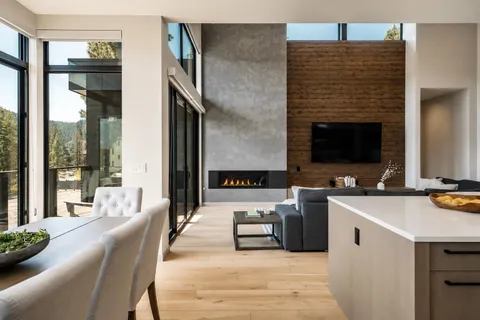 a living room with couches a flat screen tv and kitchen view