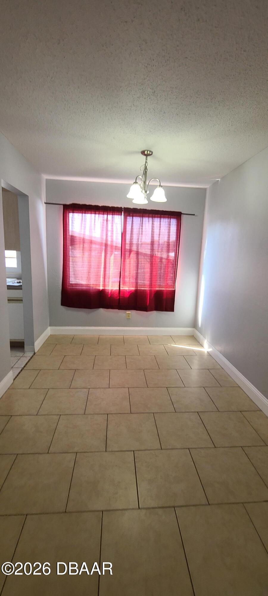 301 Ridge Boulevard, Unit 1020 South Daytona, FL 32119 - Photo 6 of 12 a view of an empty room with window and chandelier fan