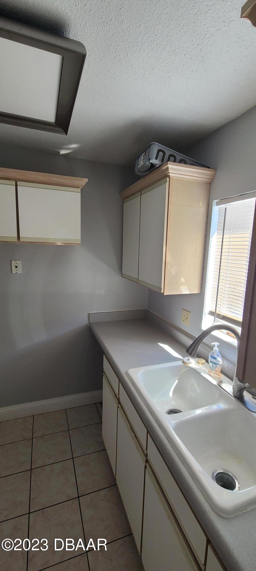 301 Ridge Boulevard, Unit 1020 South Daytona, FL 32119 - Photo 7 of 12 a kitchen with a sink and a mirror