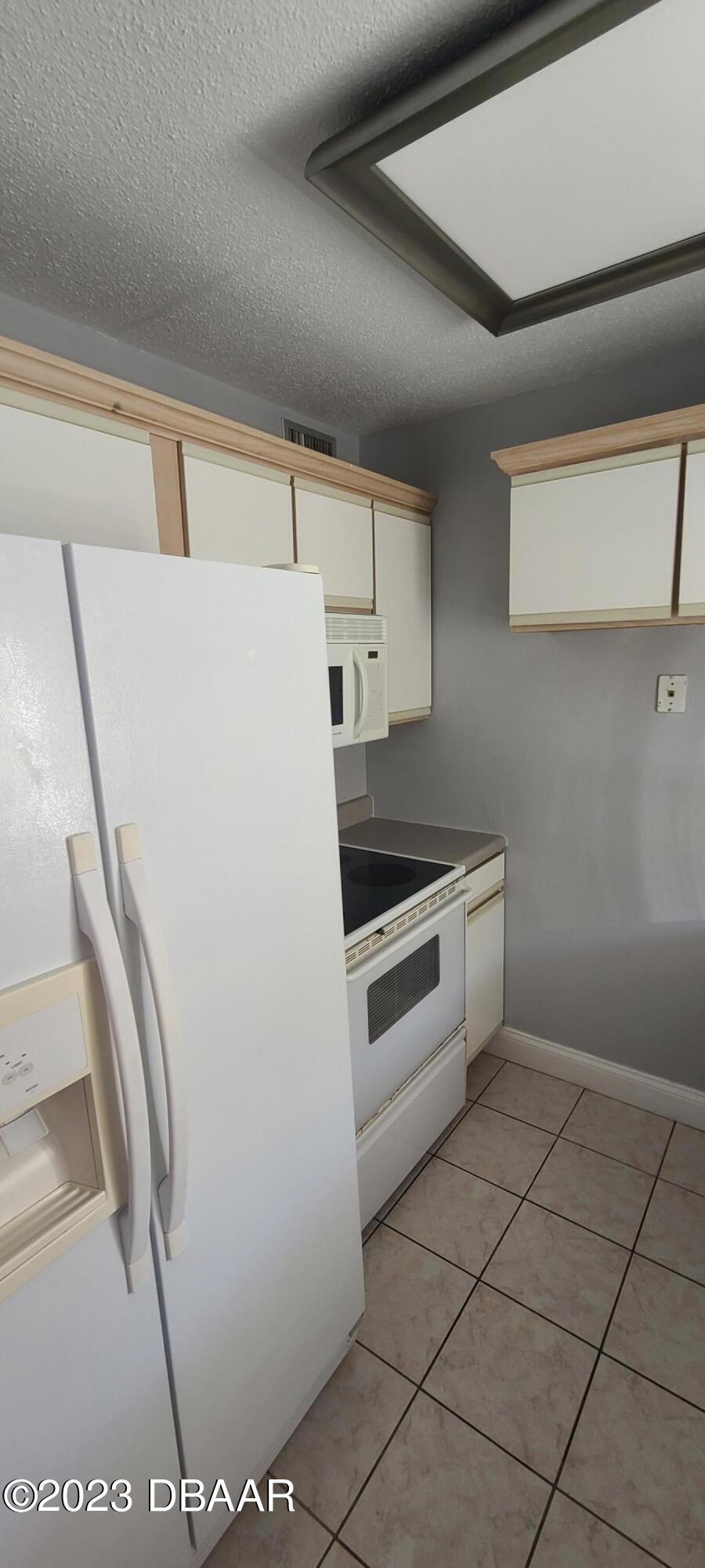 301 Ridge Boulevard, Unit 1020 South Daytona, FL 32119 - Photo 8 of 12 a white refrigerator freezer sitting inside of a kitchen