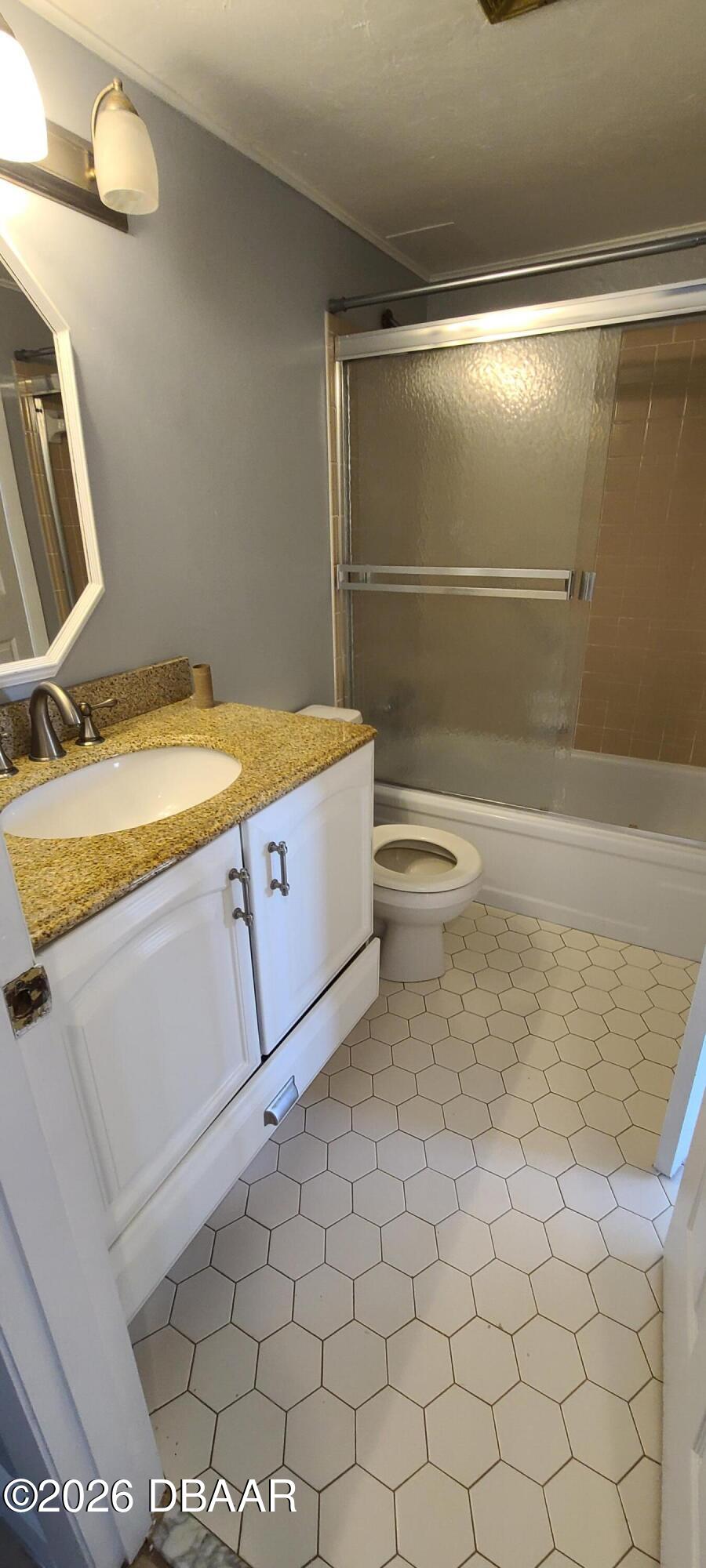 301 Ridge Boulevard, Unit 1020 South Daytona, FL 32119 - Photo 9 of 12 a bathroom with a granite countertop sink a toilet and a mirror