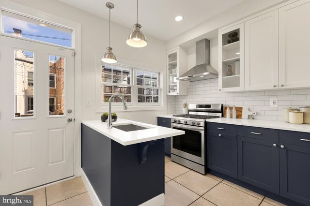 a kitchen with stainless steel appliances granite countertop a sink a stove and a refrigerator