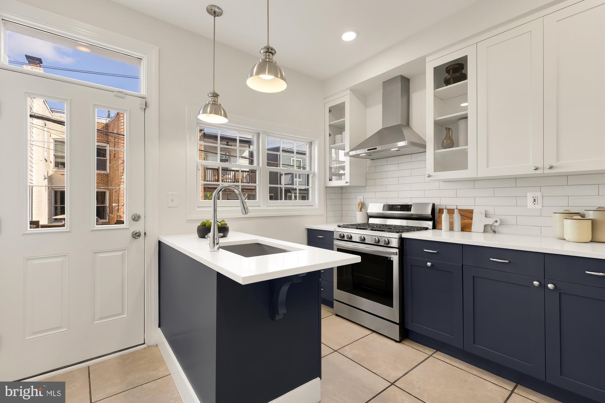 632 Acker Place Northeast Washington, DC 20002 - Photo 12 of 57 a kitchen with stainless steel appliances granite countertop a sink a stove and a refrigerator
