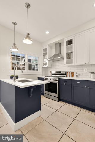 a large kitchen with stainless steel appliances granite countertop a stove a sink a counter space and cabinets