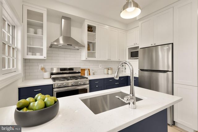 a kitchen with stainless steel appliances a sink a stove and a refrigerator