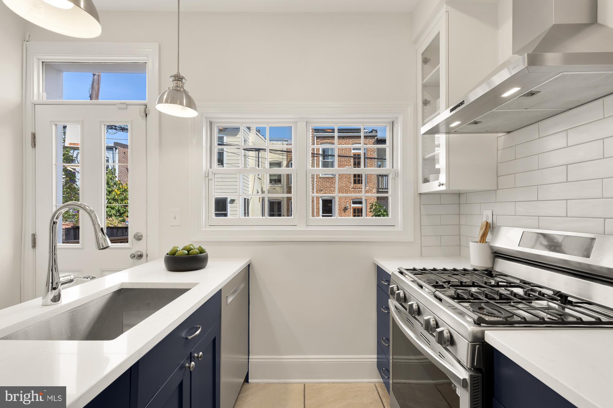 632 Acker Place Northeast Washington, DC 20002 - Photo 16 of 57 a kitchen with stainless steel appliances granite countertop a sink stove and refrigerator